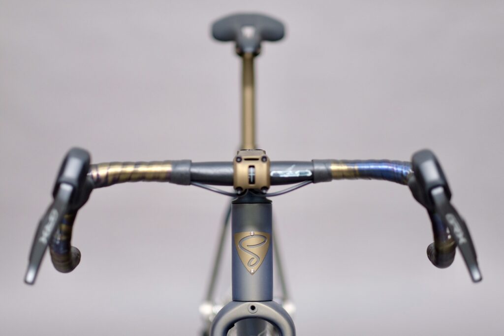 High-quality bicycle handlebars and stem featuring sleek design and branding at Simpatico Bikes.