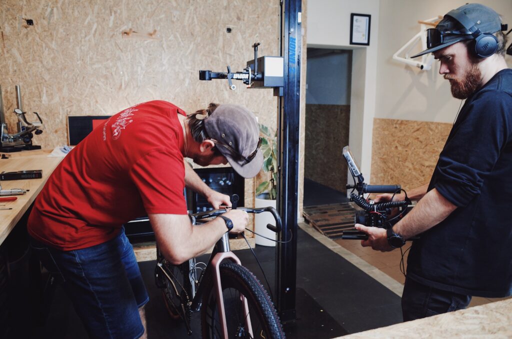 Brandon checking a Gamma Race titanium frame on the workstand during assembly in the Simpatico workshop