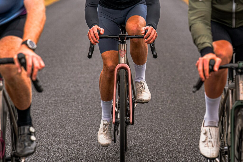 Riders on a paved road, with a Simpatico N1 in its road setup in the center